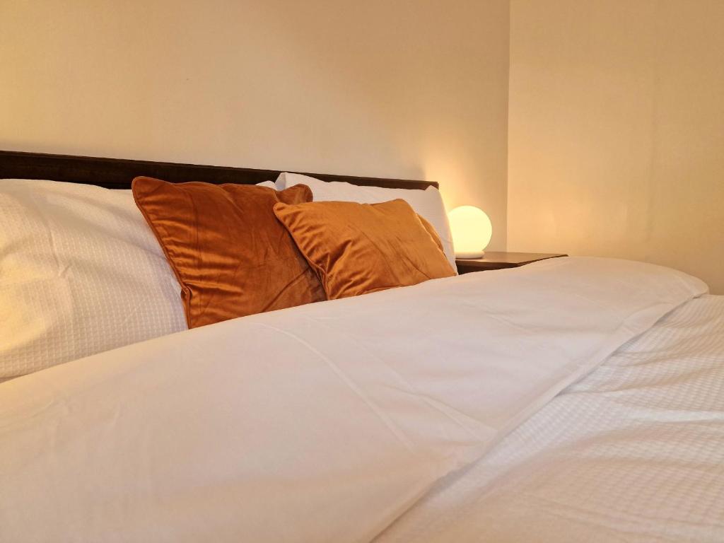 a white bed with two pillows on top of it at Millmead Apartment in central Guildford with parking in Guildford