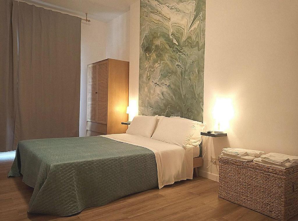 a bedroom with a bed with a painting on the wall at Casa VerdeMare in Lido di Ostia