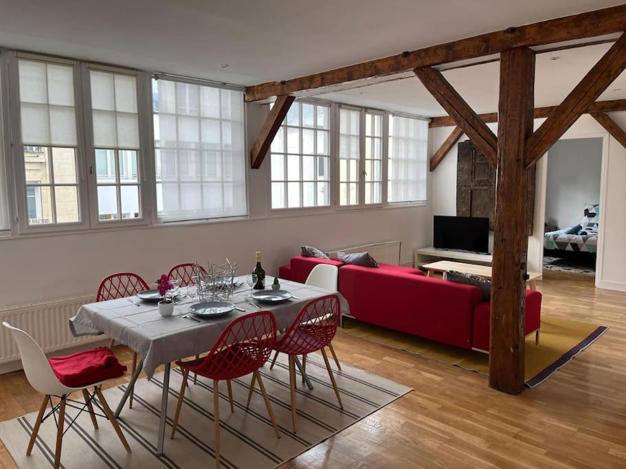 un salon avec une table et un canapé rouge dans l'établissement Loft duplex d'exception de 120m2 Paul Bert, à Paris