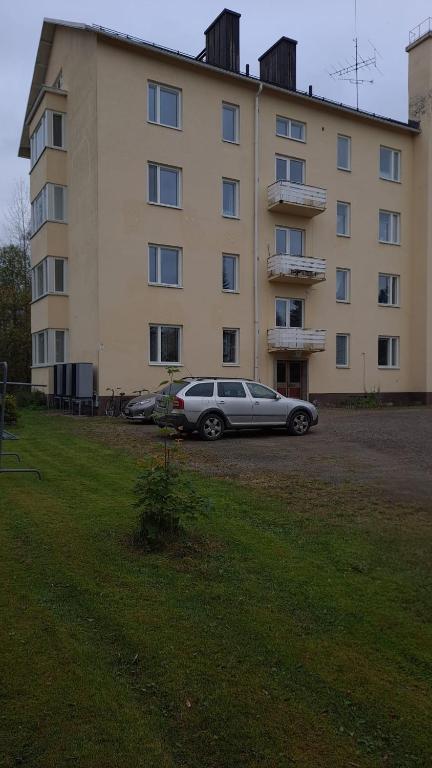 a car parked in front of a large building at Kontiomäen retrokoti in Kontiomäki