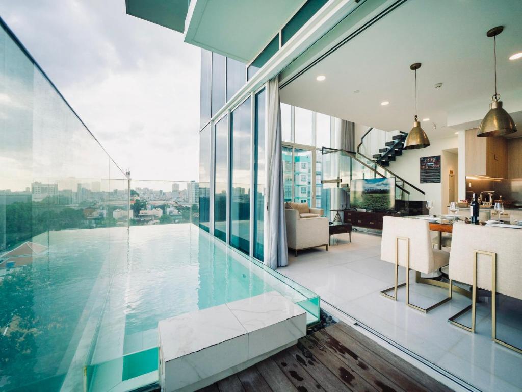 an indoor swimming pool in a house with glass walls at Serenity Saigon Sky Villas in Ho Chi Minh City