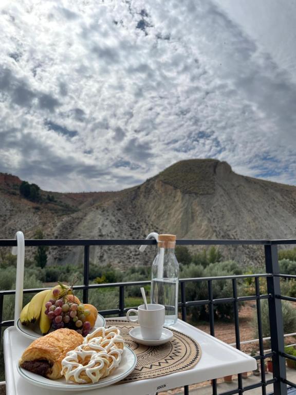 una mesa con un plato de pan y fruta en el balcón en La Rosita alojamiento rural, en Hinojares