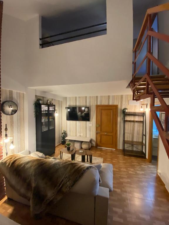 ein Wohnzimmer mit einem Sofa und einer Treppe in der Unterkunft APARTMENT SAN BERNARDO Zona Alta with free garage parking and free WIFI in Sierra Nevada