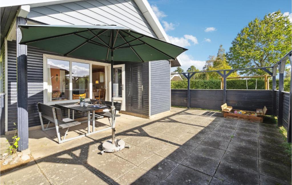 a patio with a table and an umbrella at 2 Bedroom Nice Home In Sydals in Neder Lysabild
