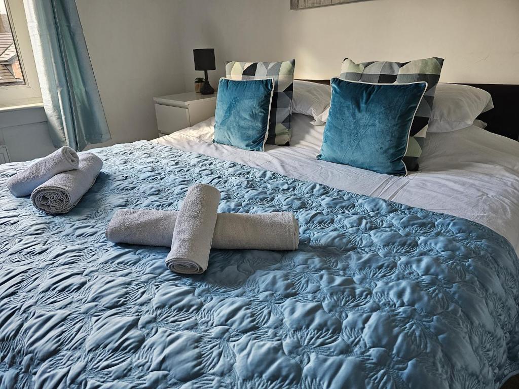 a large bed with towels and pillows on it at Snug - Meadhan Apartment in Helensburgh