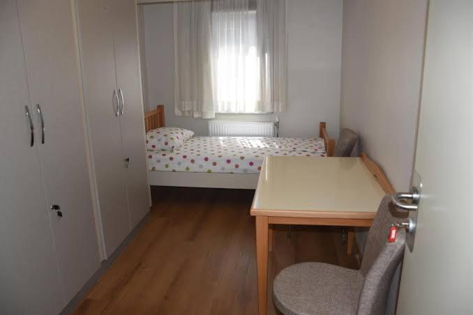 a small room with a bed and a table and a window at SAMATYA APARTı in Istanbul