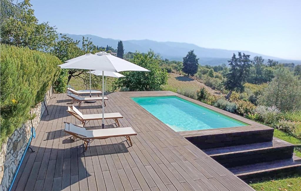 una piscina con 2 tumbonas y una sombrilla en Gorgeous Apartment In Rignano Sullarno With House A Panoramic View, en Rignano sullʼArno