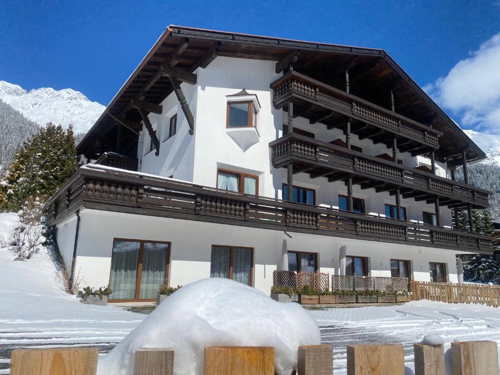 a building in the snow with a pile of snow at Quality Hosts Arlberg - AFOCH FEI - das Landhaus in Sankt Anton am Arlberg