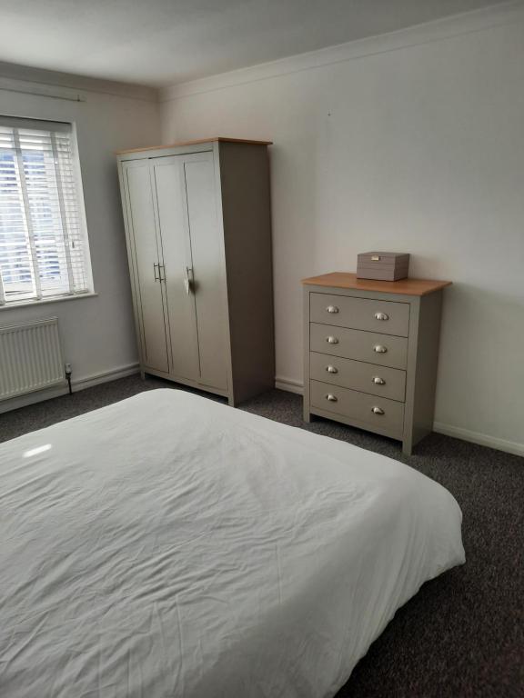 a bedroom with a large white bed and a dresser at Taunton Central in Taunton