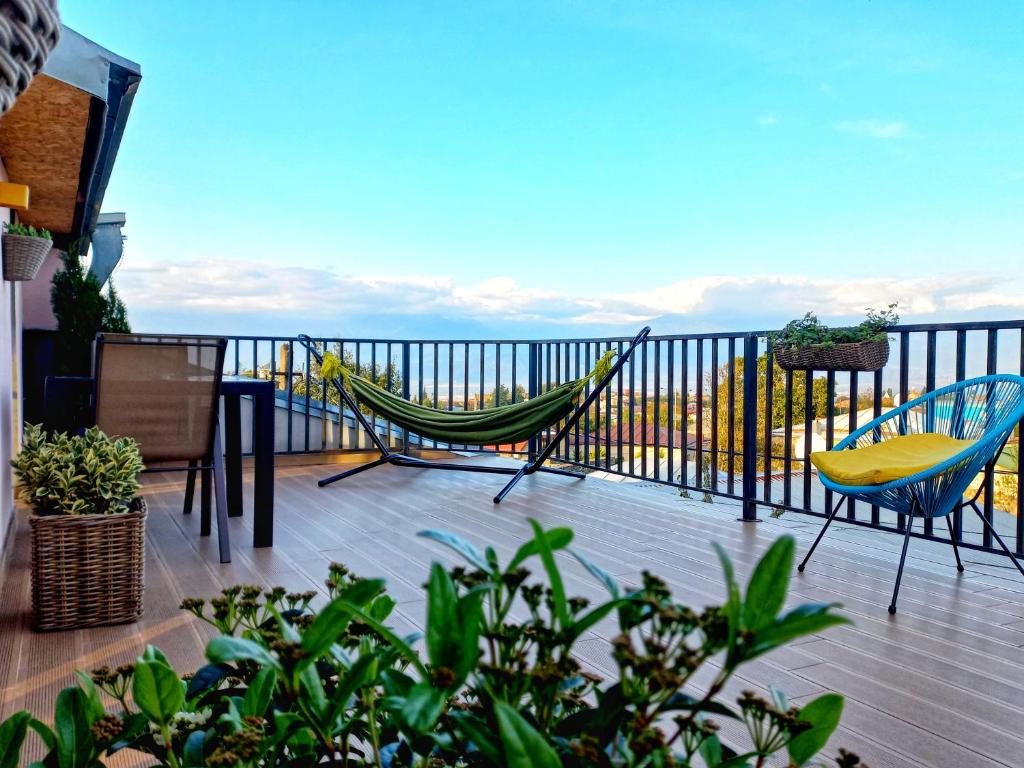 a hammock and chairs on a balcony with the ocean at Hestia - Hotel, Wine and View in Tʼelavi