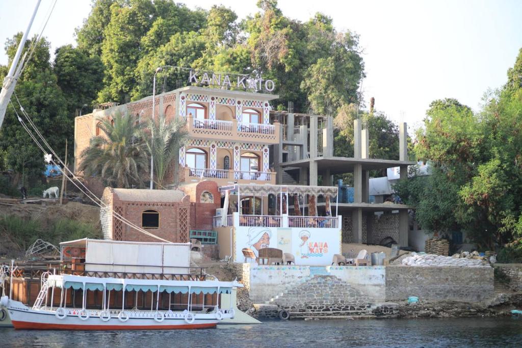 a boat in front of a house on the water at Kana Kato in Aswan