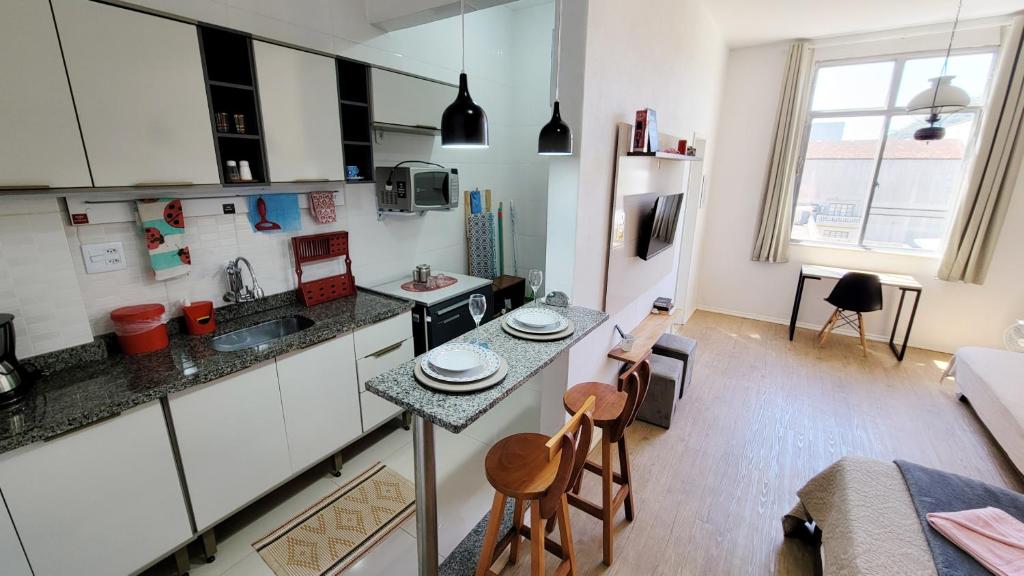 a kitchen with a counter and a table and chairs at ESTÚDIO 328 DA SERRA/TERESÓPOLIS RJ in Teresópolis