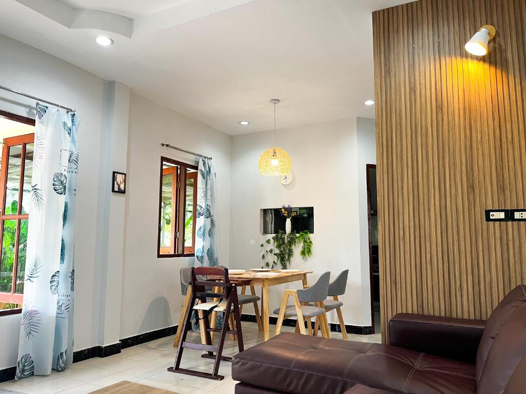 a dining room and living room with a table and chairs at 2BR Maryam villa near Tesco & beach. in Bang Tao Beach