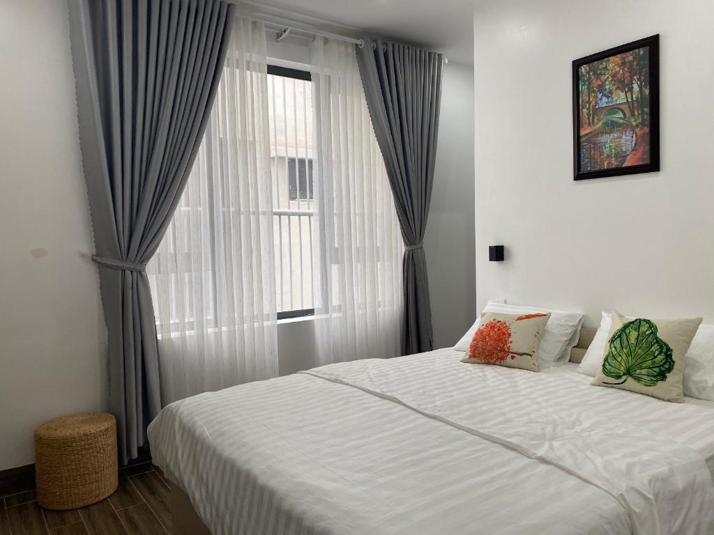 トゥイホアにあるThành Tính Hotel - Khách sạn Phú Yênの窓のある大きなベッドのある寝室