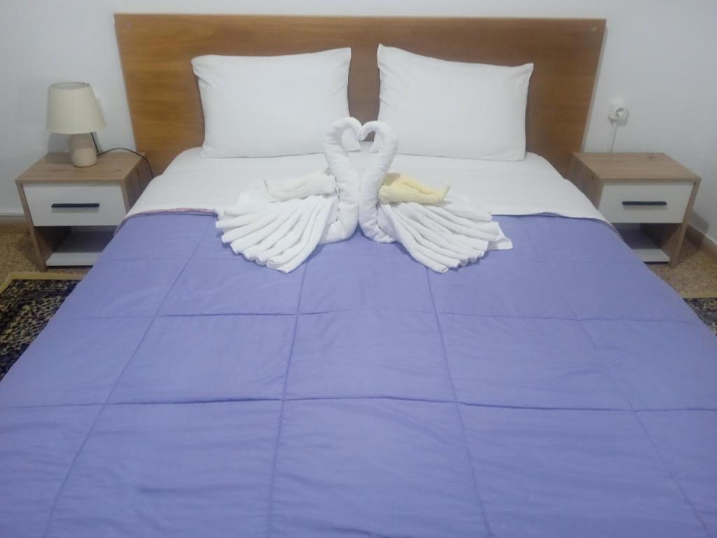 a bed with two white birds sitting on it at Classic Guesthouse Nafplion in Nafplio