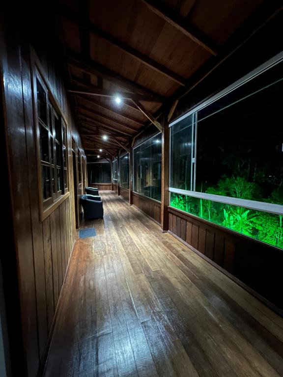 an empty hallway of a house with an aquarium at Vila dos pássaros, Quarto 02 in Itapema