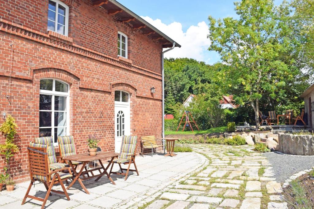 eine Terrasse mit einem Tisch und Stühlen sowie ein Backsteingebäude in der Unterkunft schöne Ferienwohnung mit Kamin und Terrasse in Sassnitz H in Dwasieden