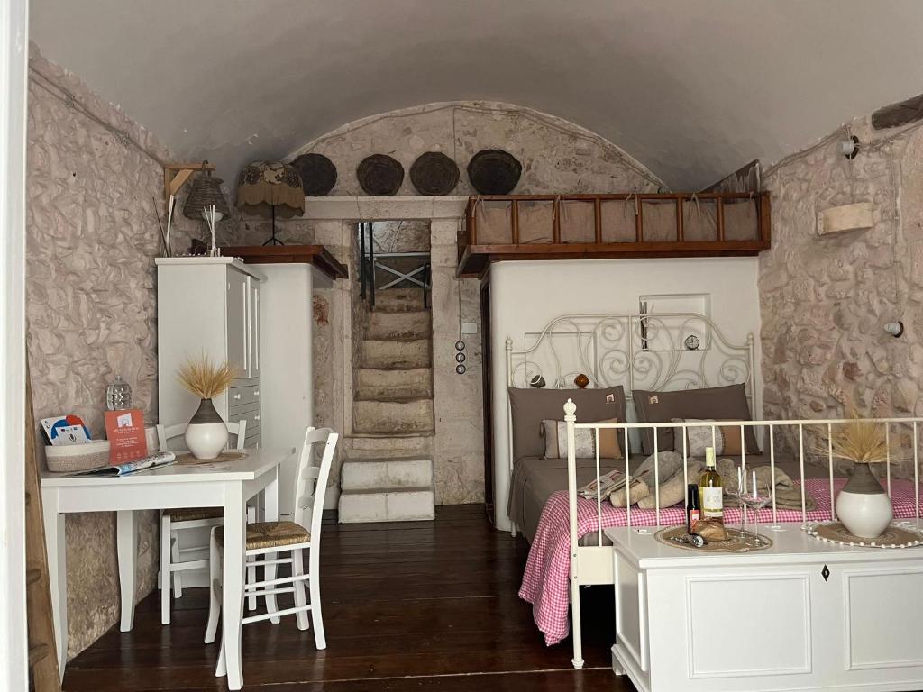 a bedroom with a bed and a desk and a table at Nel Vico Antico in Ostuni
