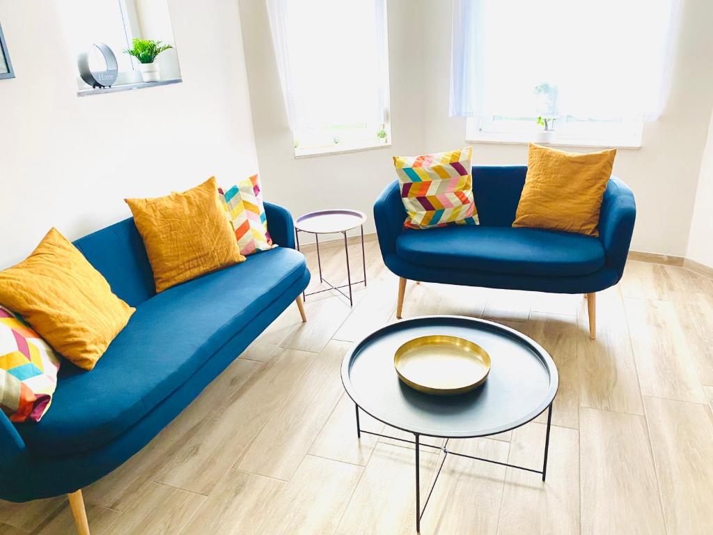 ein Wohnzimmer mit 2 blauen Sofas und einem Tisch in der Unterkunft La Villa des Coteaux - Proche Centre-ville in Lüttich