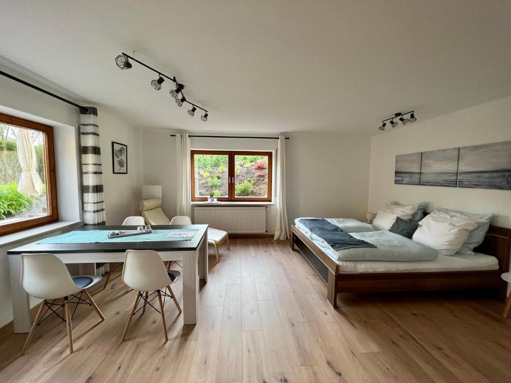 Un dormitorio con una cama y una mesa y sillas. en Ferienwohnung mit Gartenblick, en Wilhelmsdorf