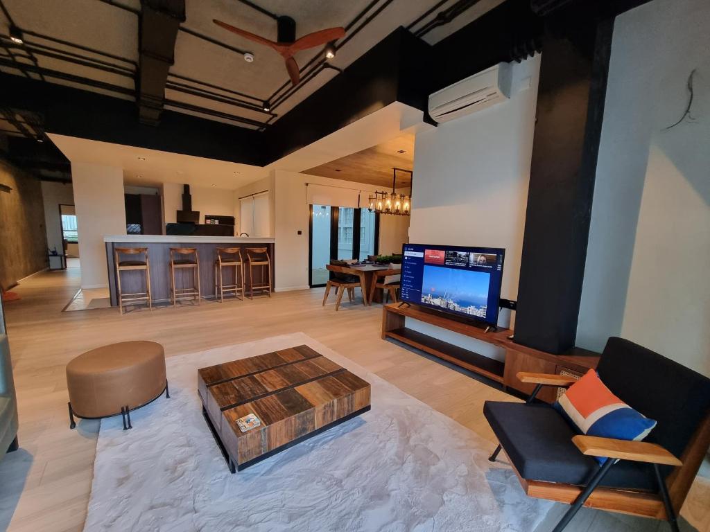 VAUX Park Street - A collection of 8 luxury lofts في كولومبو: غرفة معيشة مع تلفزيون وأريكة وطاولة
