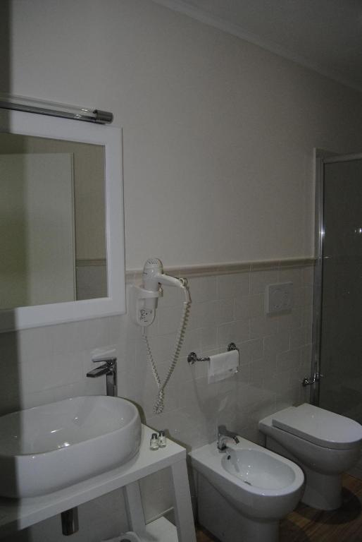 łazienka z umywalką, toaletą i lustrem w obiekcie Helios Hotel w mieście Crotone