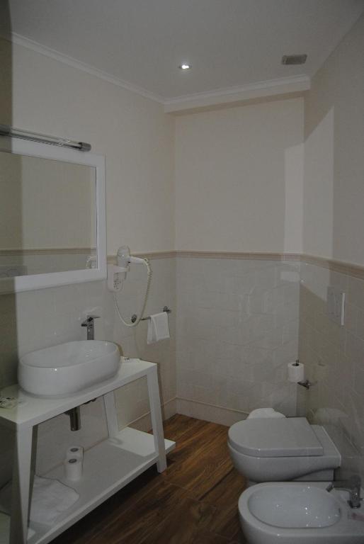 łazienka z umywalką, toaletą i lustrem w obiekcie Helios Hotel w mieście Crotone