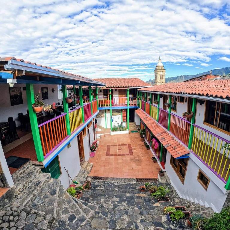 vista sul cortile di un edificio con balconi colorati di Hotel Guican de la sierra a Güicán