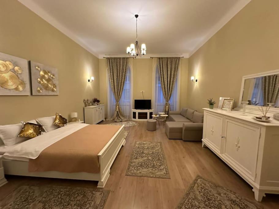 a bedroom with a large bed and a living room at Studio Montaldo in Braşov