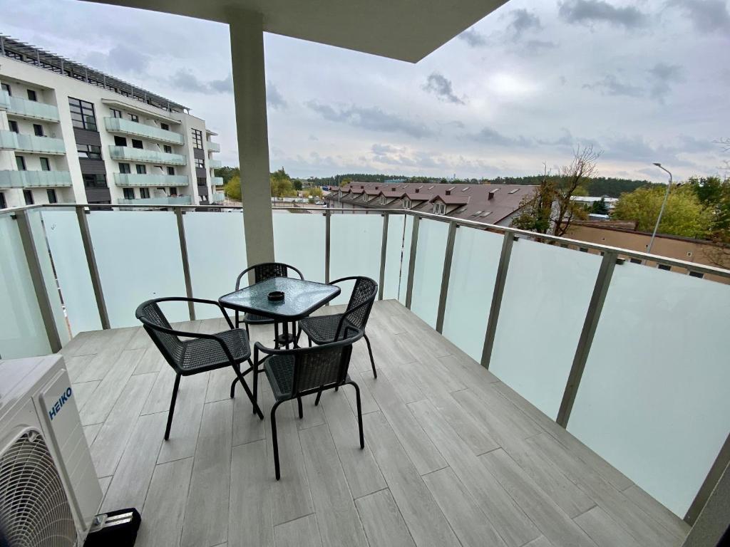 a balcony with two chairs and a table on a balcony at Apartamenty Białe nad jeziorem Białym in Augustów