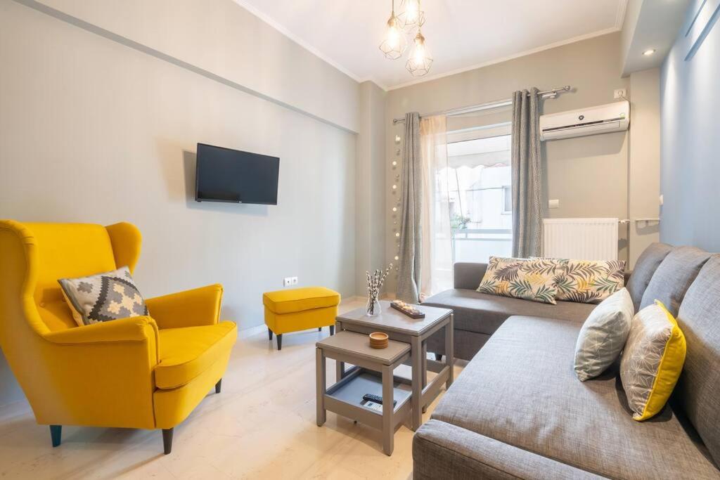 ein Wohnzimmer mit einem Sofa und einem gelben Stuhl in der Unterkunft Modern and Warm Downtown in Athen