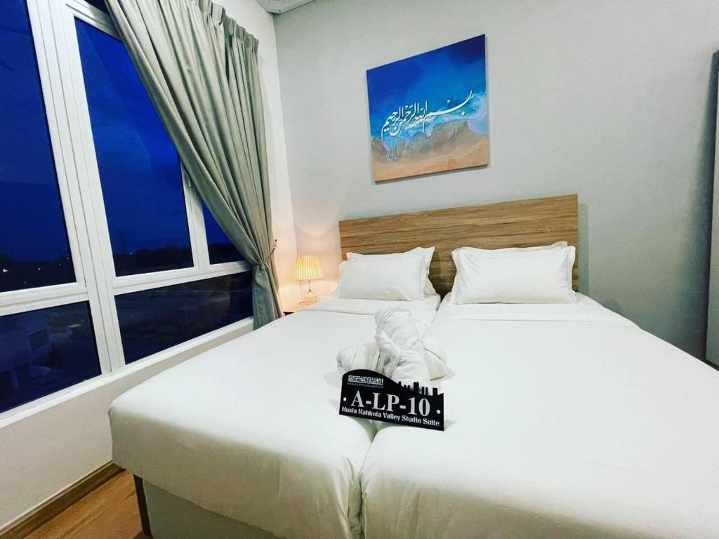 dwa łóżka w pokoju z dwoma oknami w obiekcie Husfa Mahkota Valley Studio Suite w mieście Kuantan