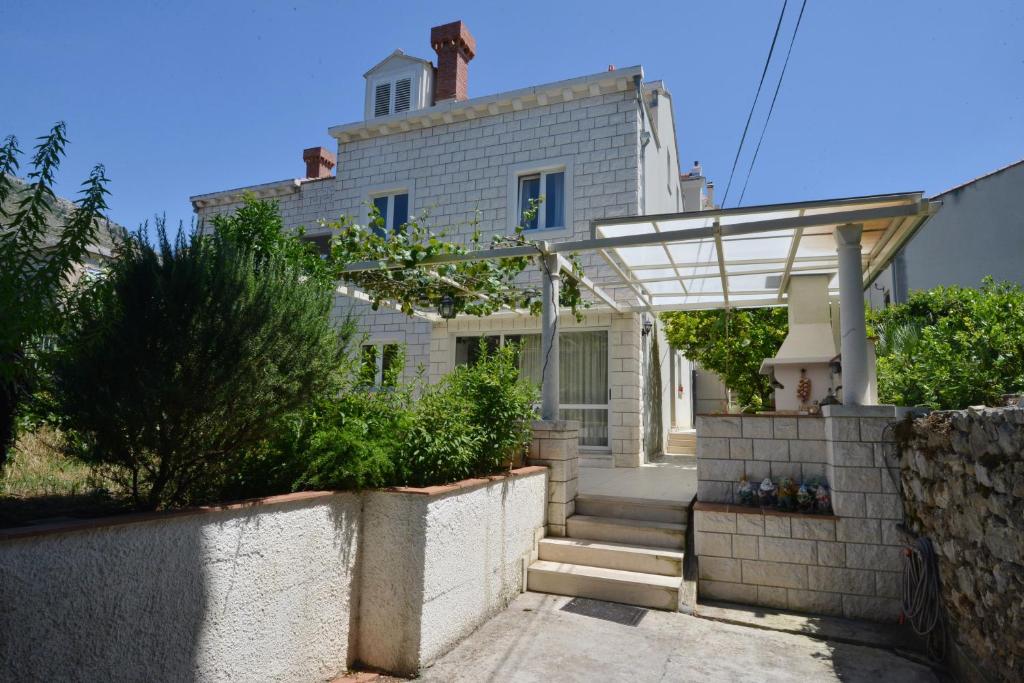 una casa blanca con una puerta y escaleras delante en Villa Elly, en Dubrovnik