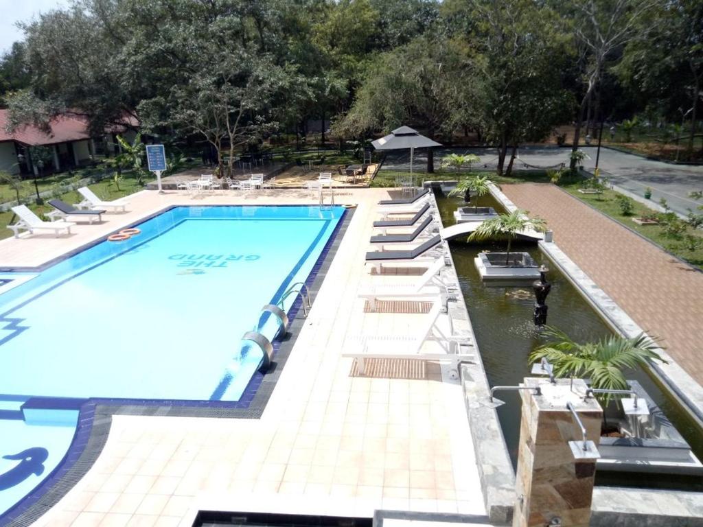 una gran piscina con tumbonas alrededor en The Grand Leisure, en Iluppankadawala