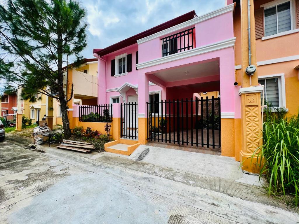 a pink and yellow house on a street at Cara Transient house in San Pablo