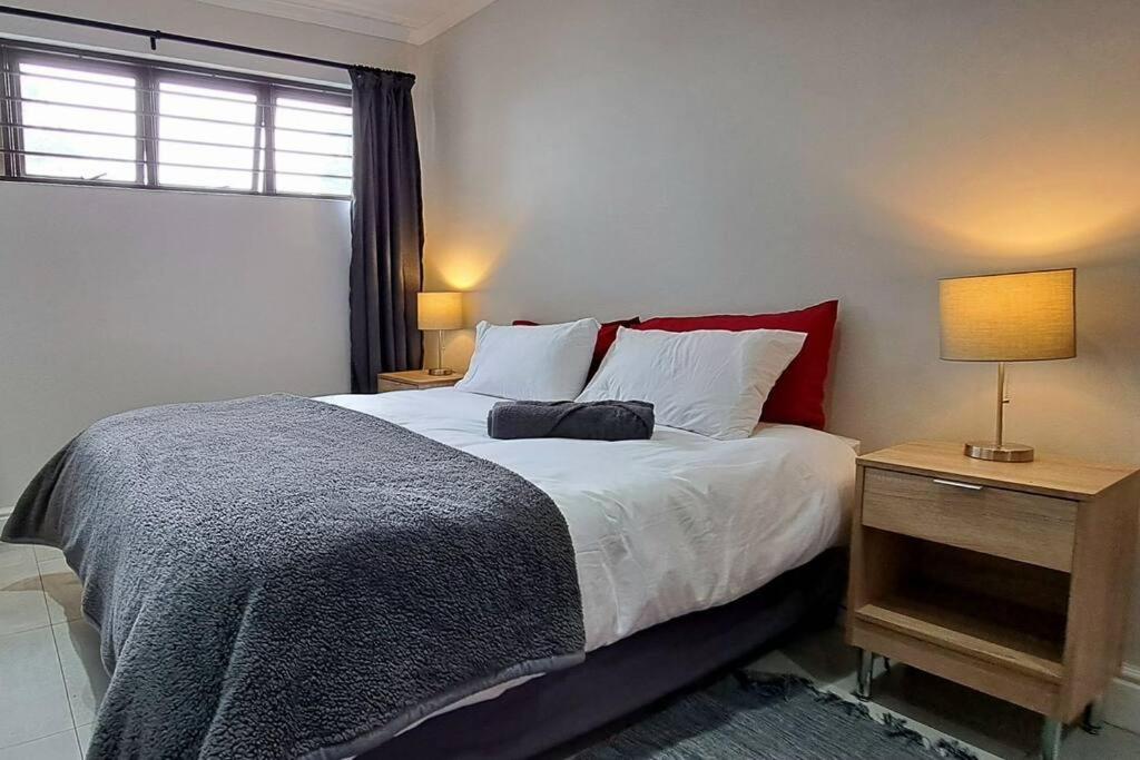 una camera con un grande letto e una finestra di Cosy Carlisle a Port Elizabeth