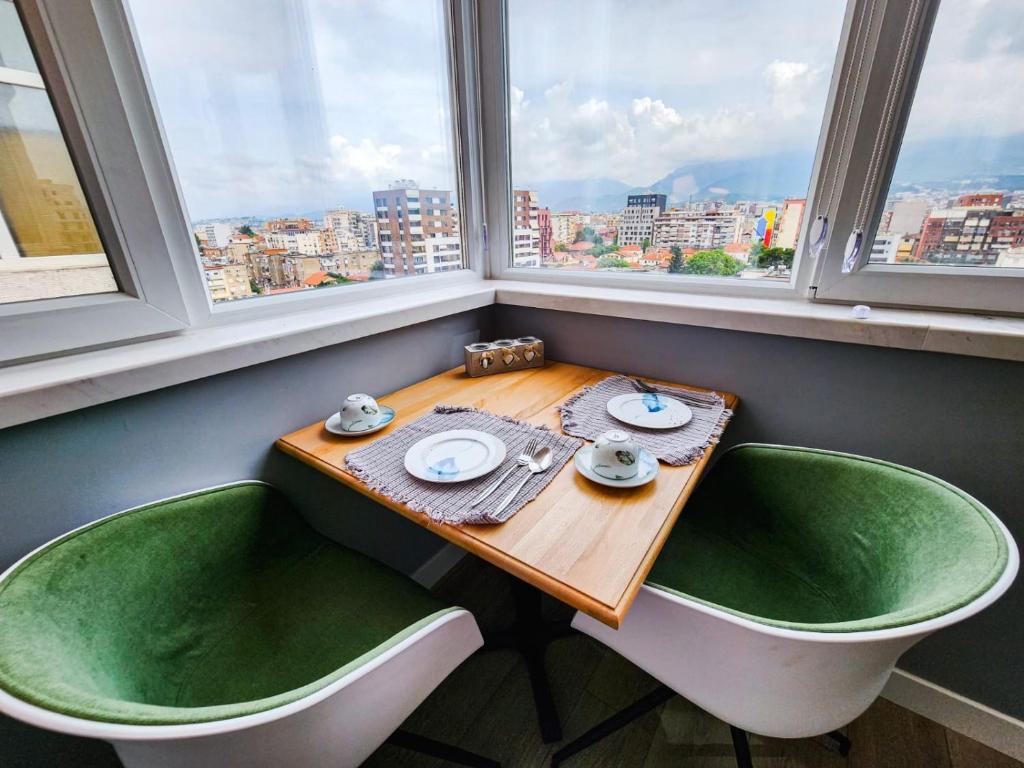una mesa y 2 sillas en una habitación con ventanas en CharmAntique Apartments, en Tirana