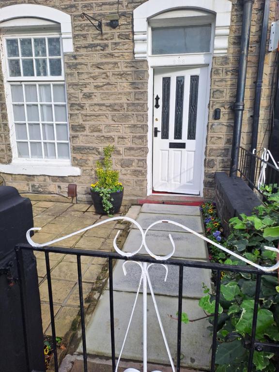 uma porta branca da frente de uma casa de tijolos em Maryann's em Huddersfield