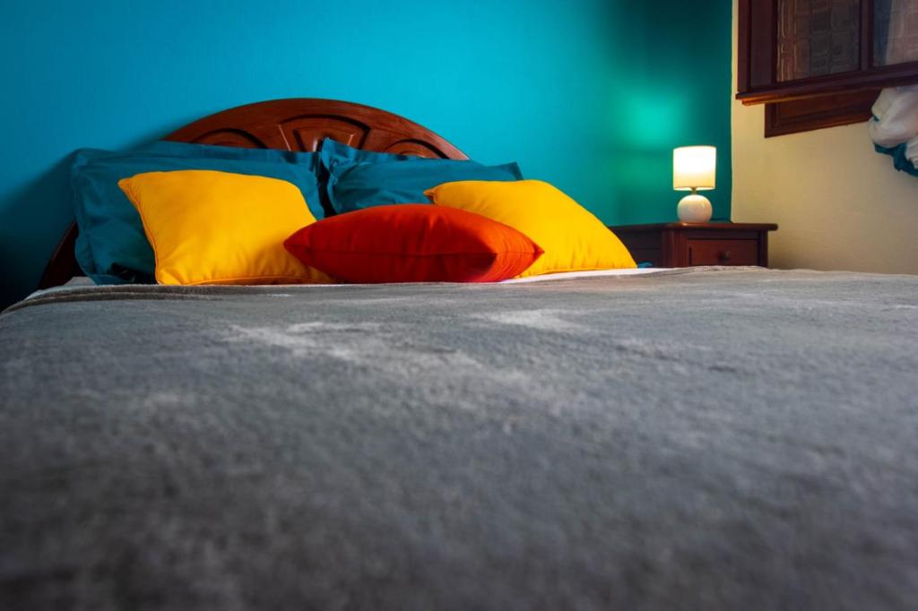 ein Bett mit bunten Kissen darüber in der Unterkunft T2 des Tortues in Bouillante