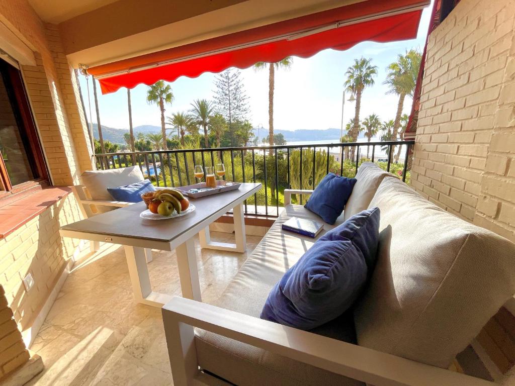 a living room with a couch and a table on a balcony at Rosa Nautica 106 in La Herradura