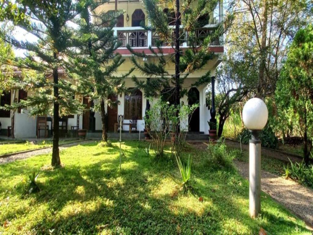 uma casa com uma luz de rua em frente em The Monkey Garden em Sigiriya
