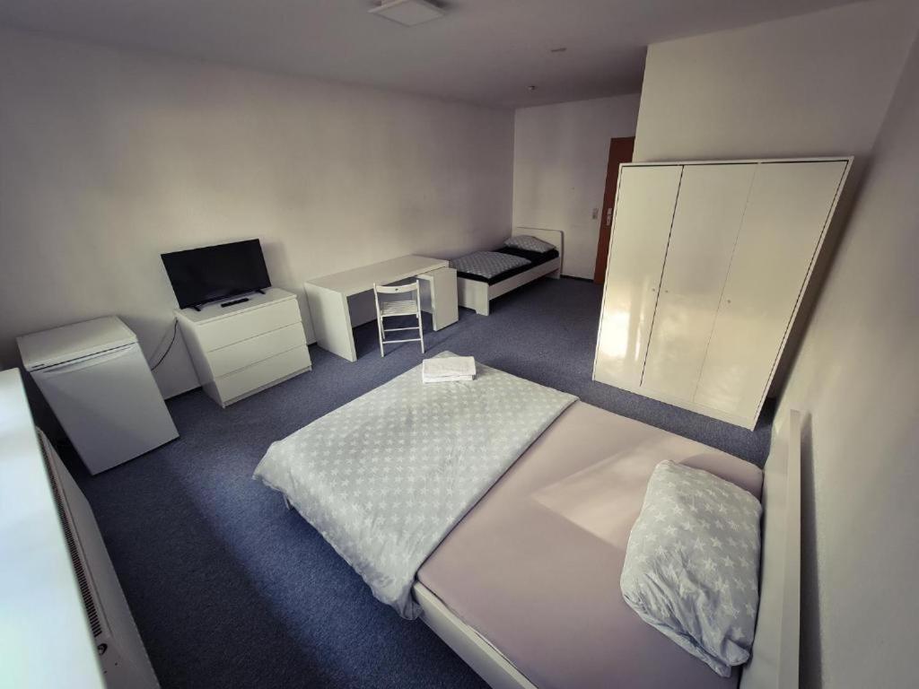 een kleine kamer met 2 bedden en een bureau bij Privat zimmer in Rostock