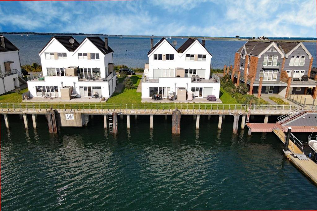 eine Gruppe von Häusern auf einem Dock neben dem Wasser in der Unterkunft Ferienwohnung-Brigantine-33-by-Seeblick-Ferien-ORO in Olpenitz