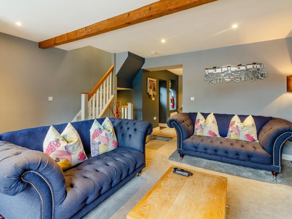 a living room with two blue couches and a table at The Lookout in Holmfirth