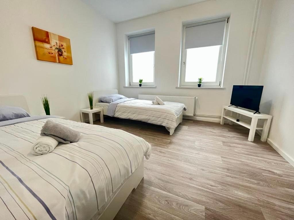 1 Schlafzimmer mit 2 Betten und einem Flachbild-TV in der Unterkunft Studio Apartments nahe Stadt in Neumünster