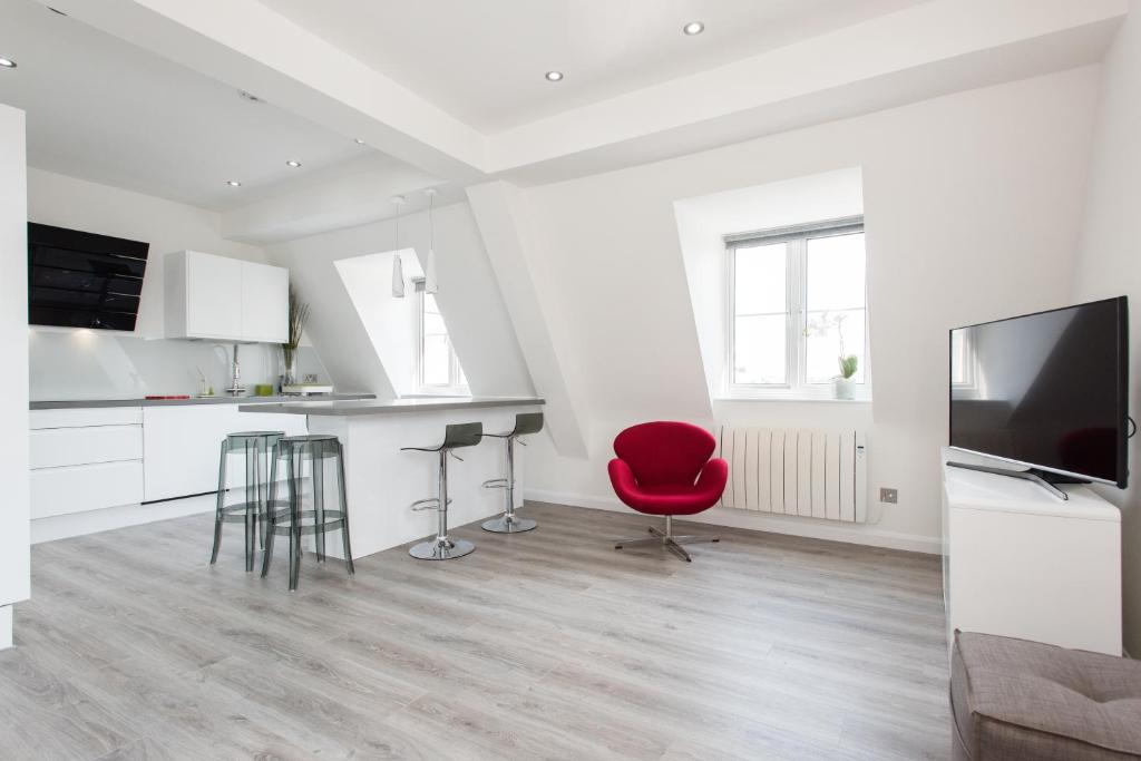 a living room with a red chair and a television at Welcome London Carnaby Street in London