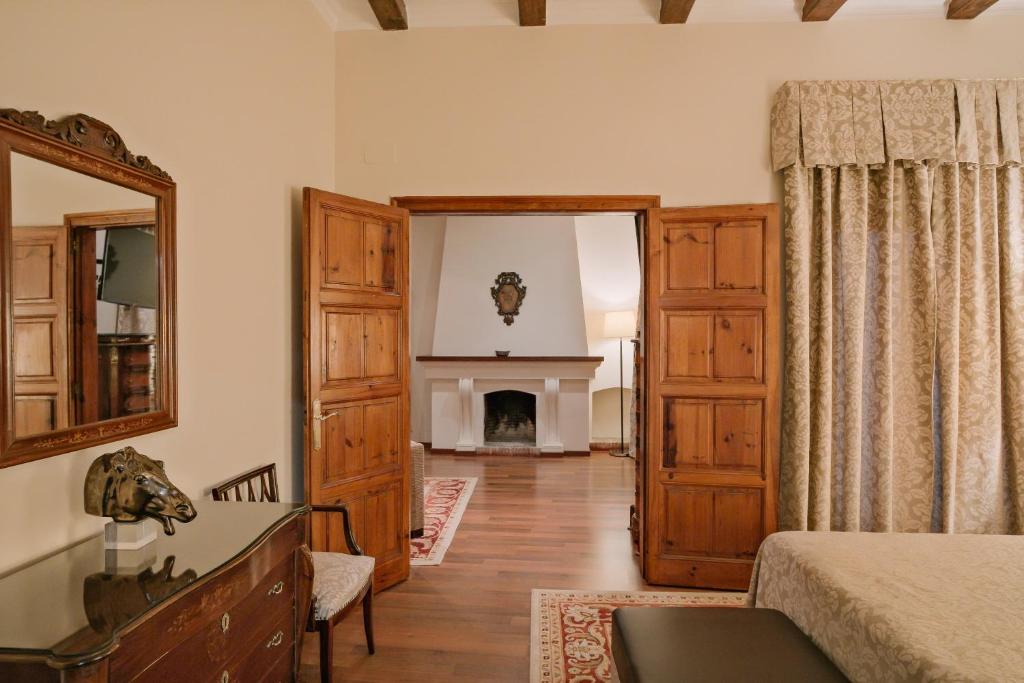a living room with a fireplace and a mirror at Rigat Park & Spa Hotel - Adults Recommended in Lloret de Mar