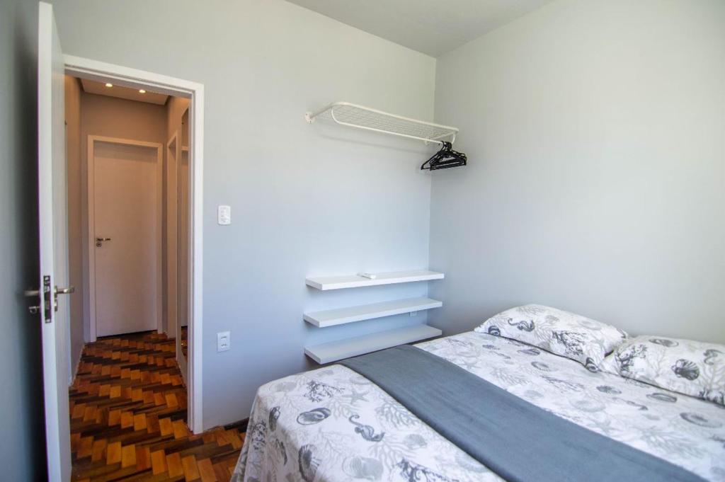 1 dormitorio con 1 cama y una luz en la pared en Fenix Canasvieiras 200 m Mar, en Florianópolis