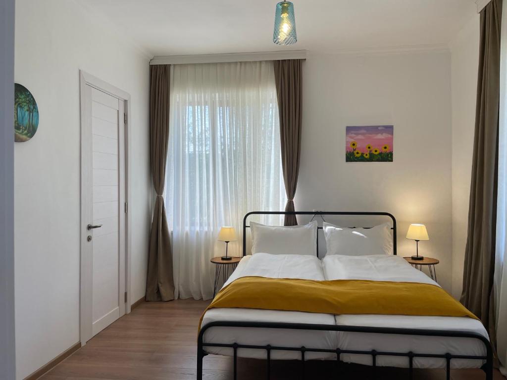 1 dormitorio con cama y ventana en Friendly Home en Tʼelavi