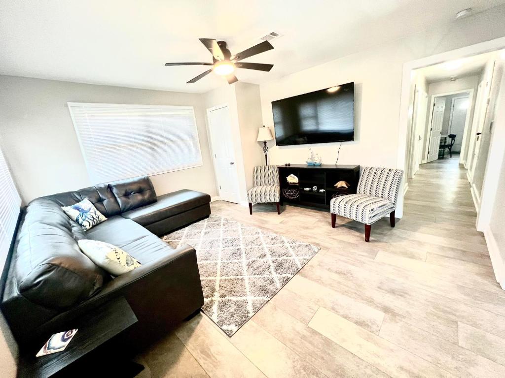 a living room with a leather couch and a tv at 4/2 Home Close to Beach, Centrally located! in Gulfport